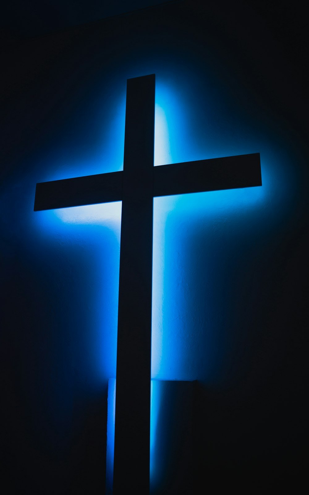Silueta unei cruci luminata in albastru