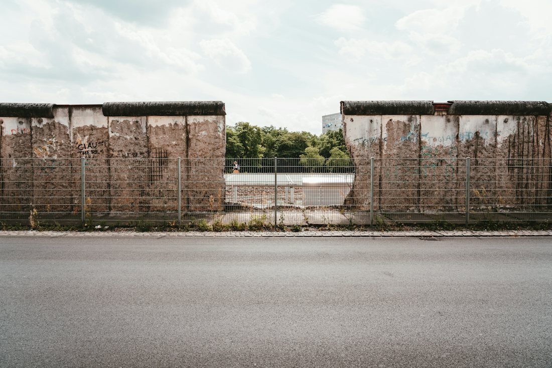 Doua fragmente din Zidul Berlinului, separate de un gard metalic